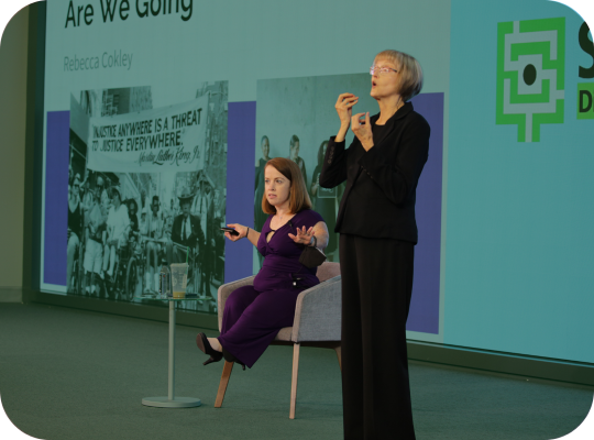 Rebecca Cokely Keynote 2024 Rebecca Cokely delivery 2024 keynote with ASL interpreter on stage.