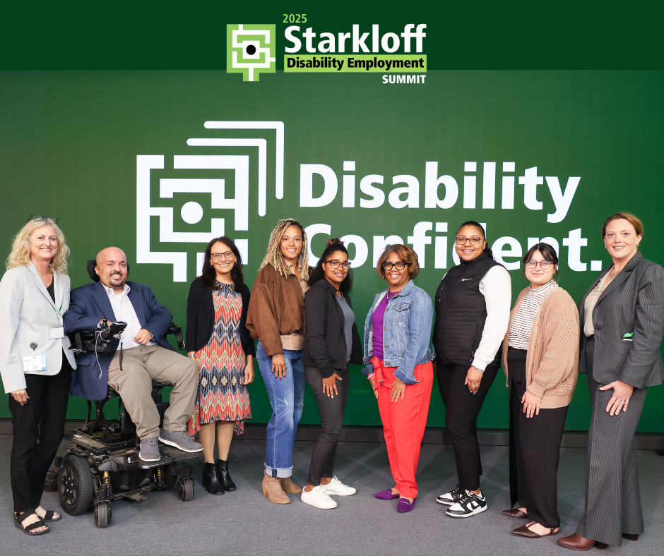 Group of Starkloff staff, board members, and attendees smiling onstage. The background is Starkloff’s Disability Confident logo.